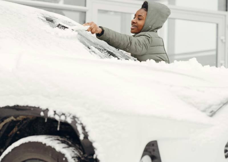 Cleaning snow from car before driving